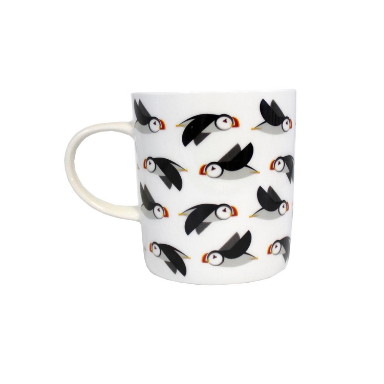 black and white puffins flying sideways on a white ceramic mug