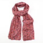 scarf with dusky pink background and oak leaves in navy and white tied loosely in a knot