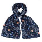 floral scarf with dark blue background and small flowers tied loosely in a knot