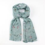 scarf with light blue background and woodpeckers on branches tied loosely in a knot