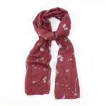 scarf with red background and woodpeckers on branches tied loosely in a knot