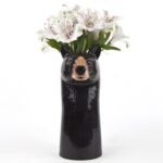 black bear vase by quail ceramics shows tall black vase with bear's face and flowers on top