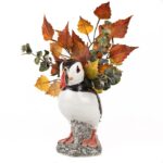 puffin vase by quail ceramics shows the bird with red feet and colourful beak with autumn leaves in the top