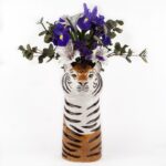 tiger vase by quail ceramics shows black, whist and orange vase with tigers head and flowers