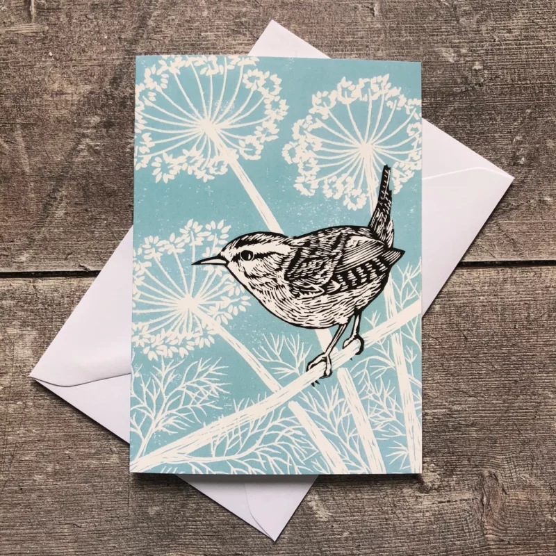 wren on branch against fennel on pale blue background