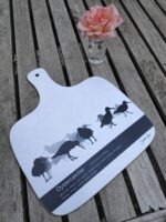 black and white oystercatcher chopping board on beige table with pink rose