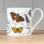 Butterflies mug by madeleine floyd has five butterflies painted in colour against a white background with some delicate flowers