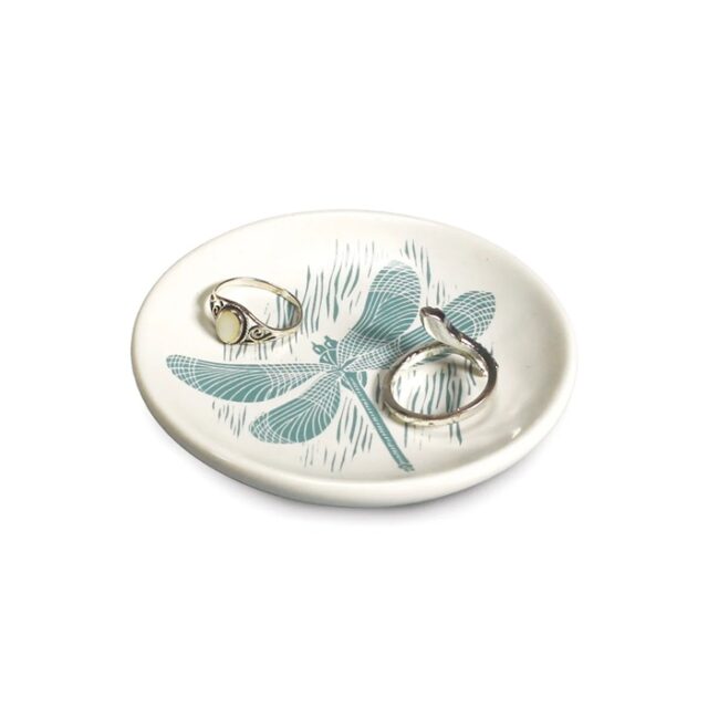 dragonfly trinket dish by kate heiss shows a white ceramic dish with a blue dragonfly on it and rings in it