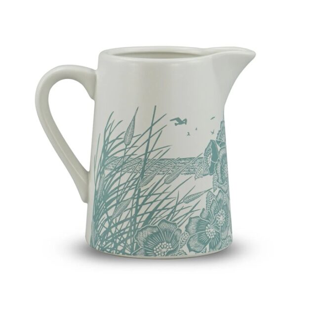 ceramic jug powder blue by kate heiss shows a white jub with pale blue illustration showing poppies and grasses growing on the beach with the sea and a seabird behind