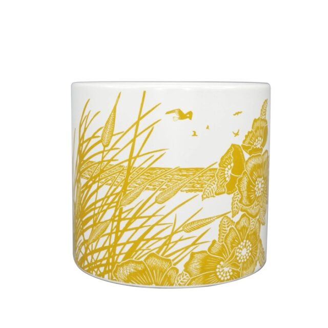Ceramic post mustard by kate heiss shows a white ceramic pot with yellow decoration around of poppies with a beach and sea behind
