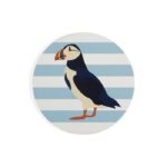 Shows a ceramic coaster with a puffin in profile against a blue and white striped background which make up the set of RSPB Ceramic Puffin Coasters