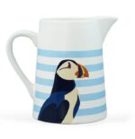 RSPB puffin jug shows a white jub with horizontal light blue stripes and a puffin's head and body in blue black and white with a colourful beak