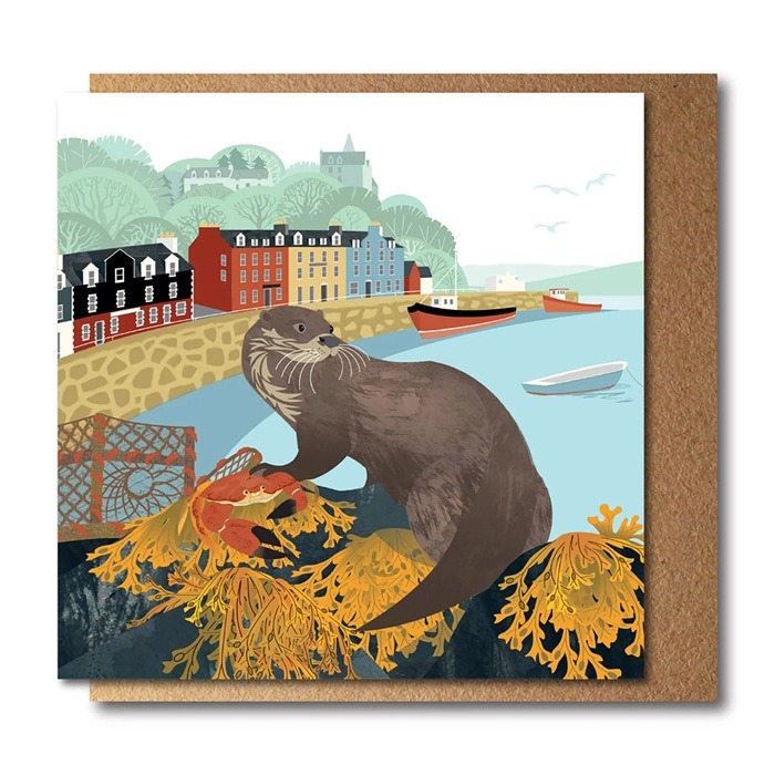 Otter Greetings Card by Rachel Hudson shows a large otter no a cliff top overlooking the sea shore with buildings in the background