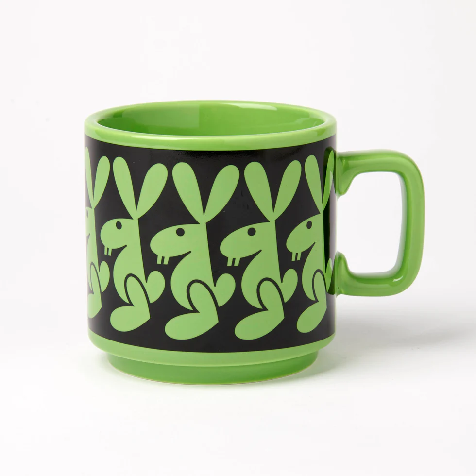 Hornsea Rabbit Mug by Magpie shoes a stylised rabbit in green against a black background, repeated around the mug