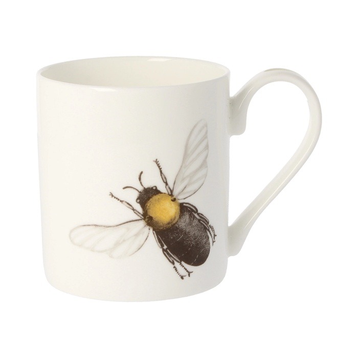 Bee mug by holly lasseter shows a black bee with golden thorax and translucent wings on a white mug