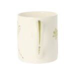 Dragonfly mug by holly lasseter shows a leaf depicted on the handle of a white mug