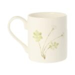 Dragonfly mug by holly lasseter shows delicate flowers on green stems on the reverse of a white mug