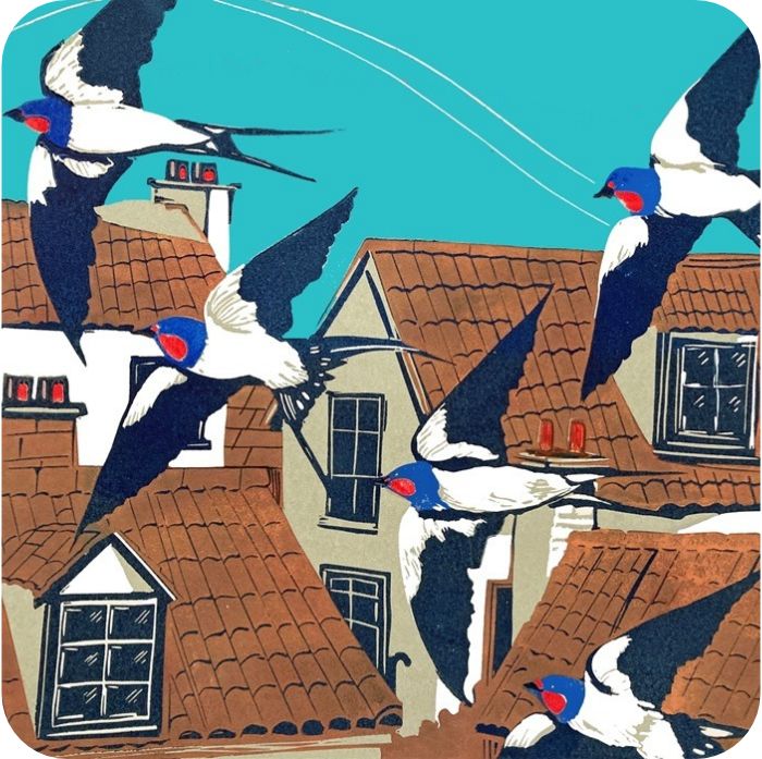 Swallows Placemat by Sue Welfare shows black and white birds with red and blue heads and long black streamer tails swooping in front of terracotta rooves