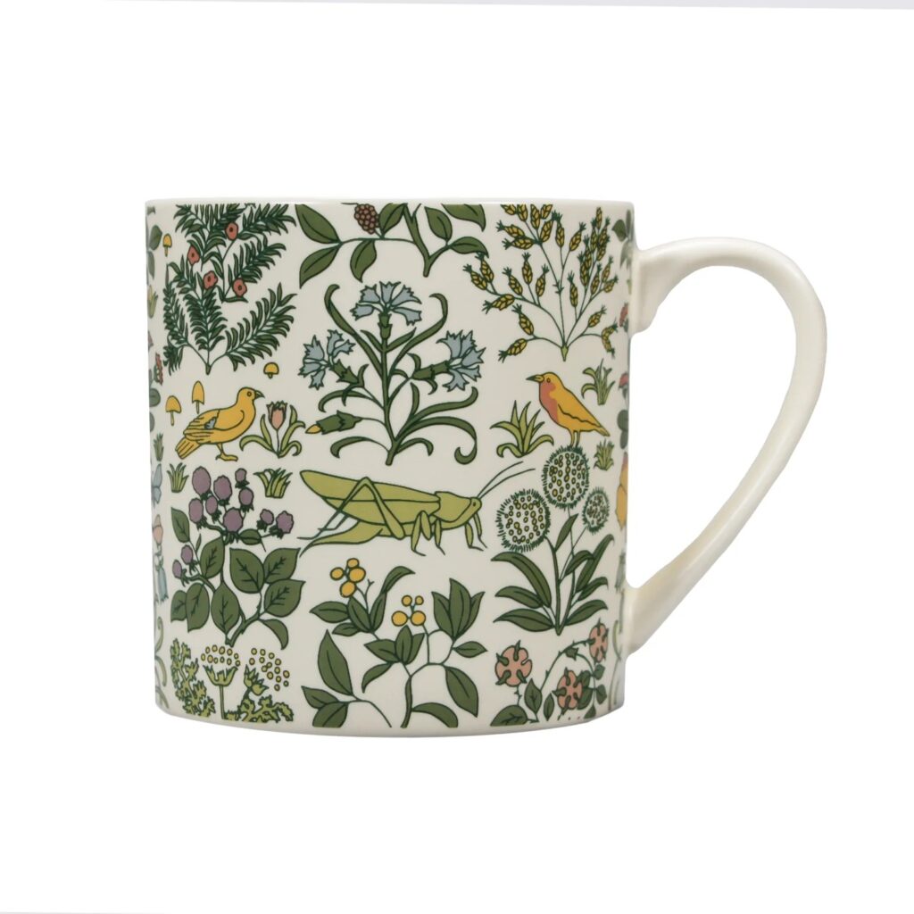 Arts and Crafts Society Grasshopper Mug shows a mug decorated with birds vegetation and a grasshopper in green against a cream background