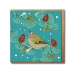Goldcrest in fir tree greetings card shows a small brown bird with white around the eye perched in a fir tree with fir cones around and small flakes of snow