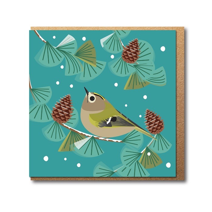 Goldcrest in fir tree greetings card shows a small brown bird with white around the eye perched in a fir tree with fir cones around and small flakes of snow