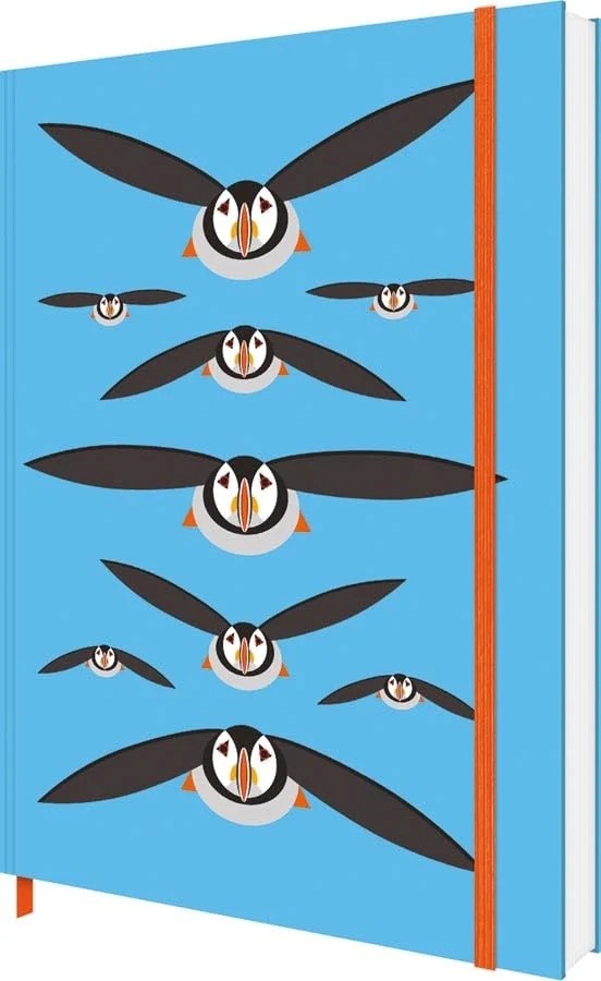i like birds notebook shows black stylised puffins flying against a blue background. A red elastic ribbon runs top to bottom around the book